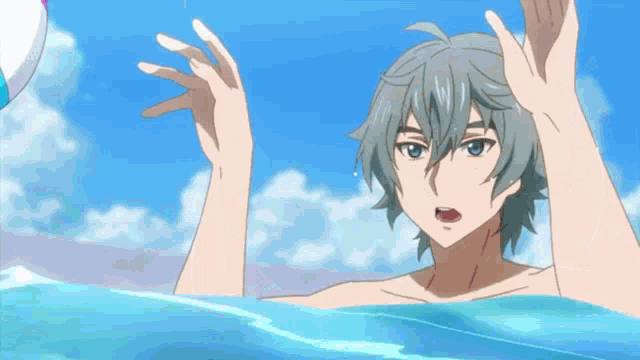 a man is holding a beach ball in the water .