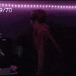 a person is standing in a dark room with a purple light behind them