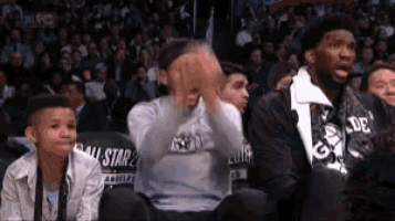 a group of people are watching a basketball game in a stadium .