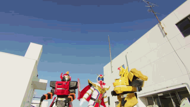 three robots standing in front of a white building