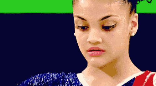 a close up of a woman 's face with a green background behind her