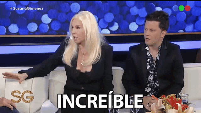 a woman and a man are sitting on a couch with the word increible written on the screen