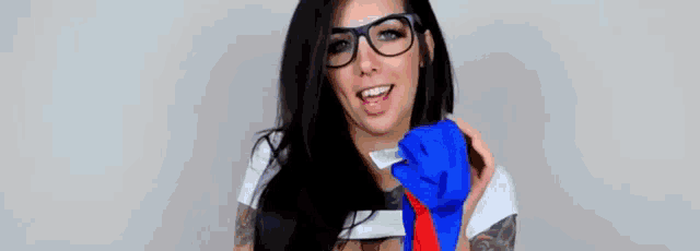 a woman is holding a pair of blue and red gloves in her mouth .