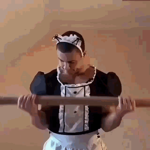 a man dressed in a maid costume is holding a barbell .