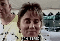 a woman is wearing a yellow shirt that says i 'm tired on it .