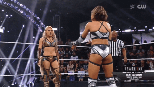 two women wrestling in a ring with a sign that says deadline next saturday on it
