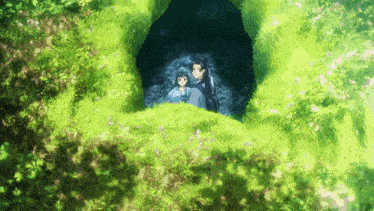 a man and a woman are sitting in a grassy area