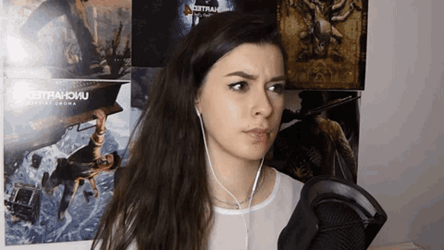 a woman wearing ear buds stands in front of a poster that says ' zetrahoivu ' on it