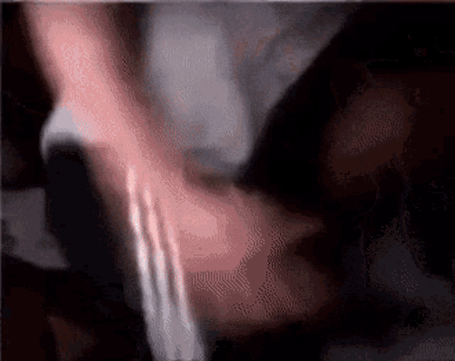 a blurry picture of a person 's arm with a white shirt