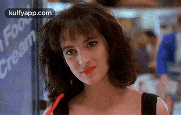 a woman with red lipstick is drinking a straw in front of a sign that says ice cream .