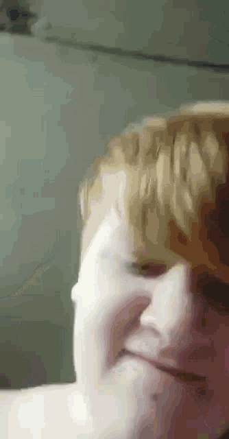 a close up of a person 's face with blonde hair making a funny face