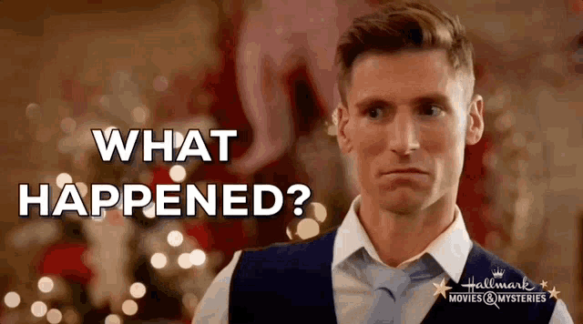 a man in a suit and tie says what happened in front of a christmas tree