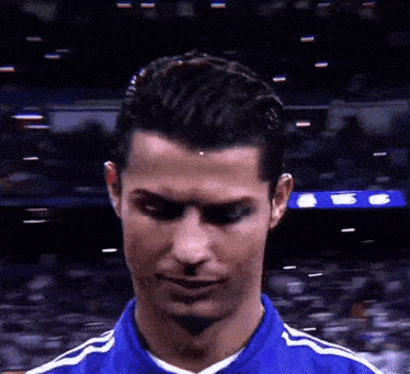 a close up of a man 's face with a blue shirt on