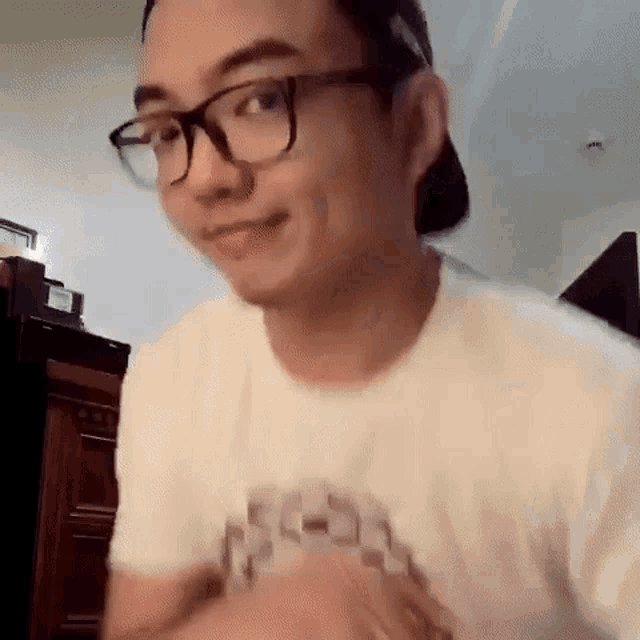 a man wearing glasses and a baseball cap is making a face .