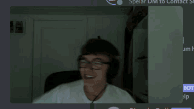a man wearing glasses and headphones is smiling in front of a screen that says ' speiar dm to contact '