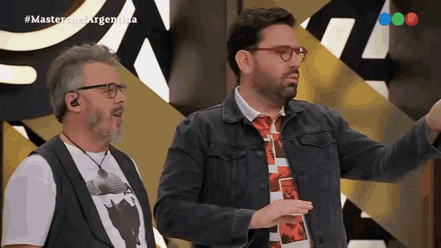 two men standing in front of a screen that says #masterchefargentina