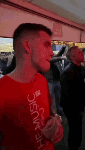 a man in a red shirt that says the music