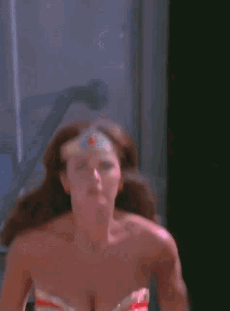 a woman in a wonder woman costume is looking at the camera .