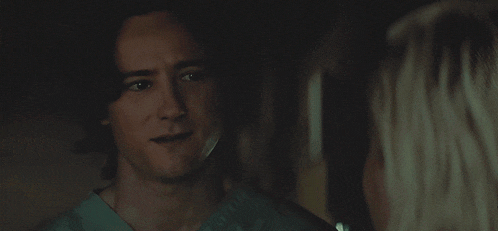 a man in a scrub top is smiling at a woman