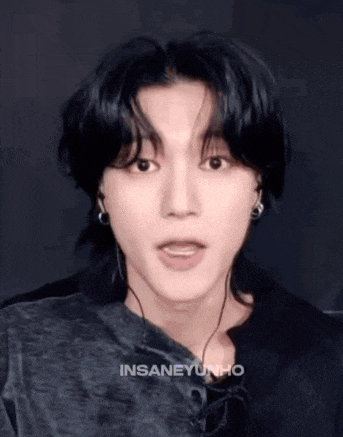a young man wearing headphones and a black shirt is making a face .