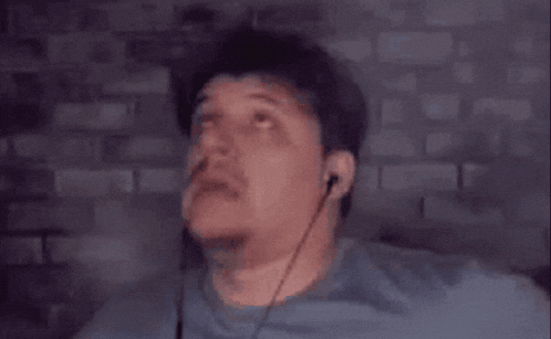 a man is wearing headphones and praying with his hands in the air .