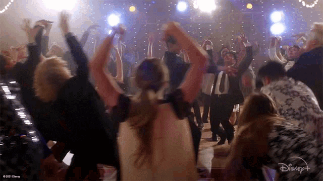 a group of people are dancing in front of a disney + logo