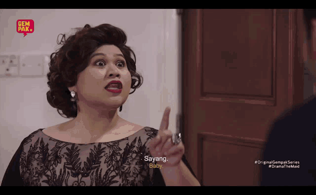 a woman in a black dress is talking to a man and says sayang baby