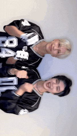 two men wearing black jerseys with the number 8 on them are posing for a picture .