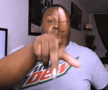 a man wearing a mtn dew shirt is pointing