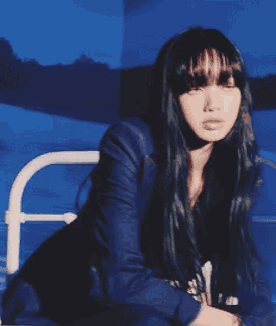 a woman with long black hair is wearing a blue jacket and black dress