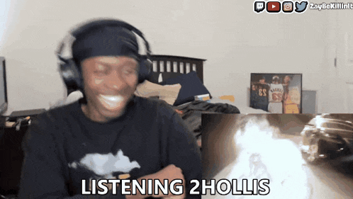 a man wearing headphones says listening 2 hollis in front of a fire