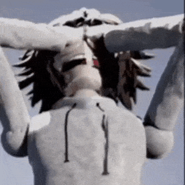 a close up of a statue of a person with their hands on their head .