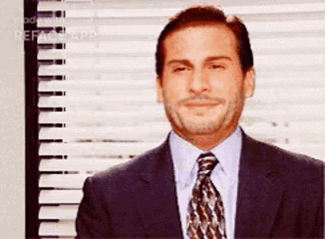 a man in a suit and tie is smiling in front of blinds