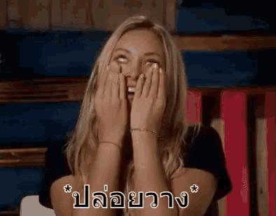 a woman is covering her face with her hands and laughing in a foreign language .