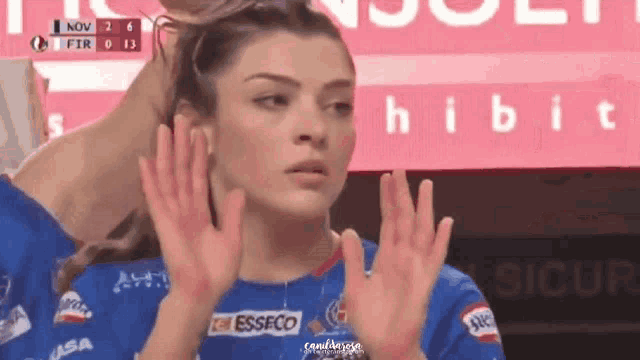a woman wearing a blue shirt with the word esseco on the front