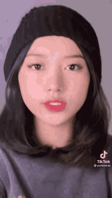 a woman wearing a black beanie and a t-shirt with tiktok written on it