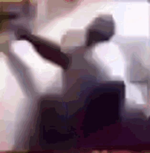 a blurry picture of a person sitting on a couch .