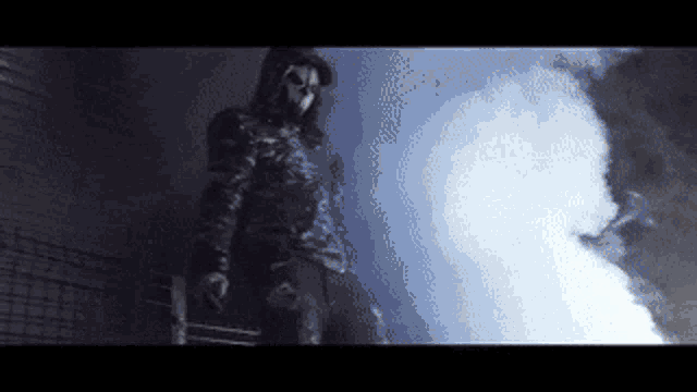 a person wearing a mask is standing in a dark room with smoke coming out of it