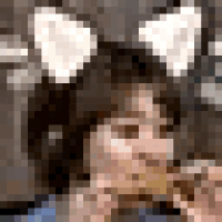 a girl with cat ears is eating a banana .