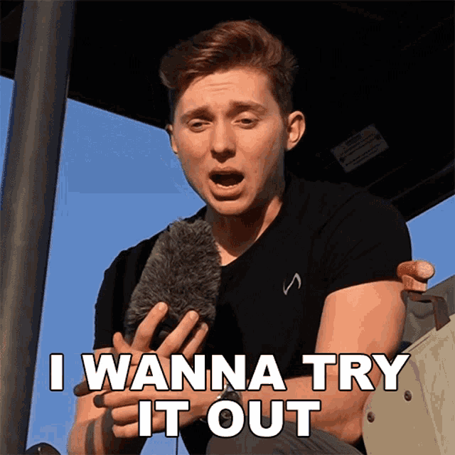 a man holding a microphone with the words i wanna try it out below him