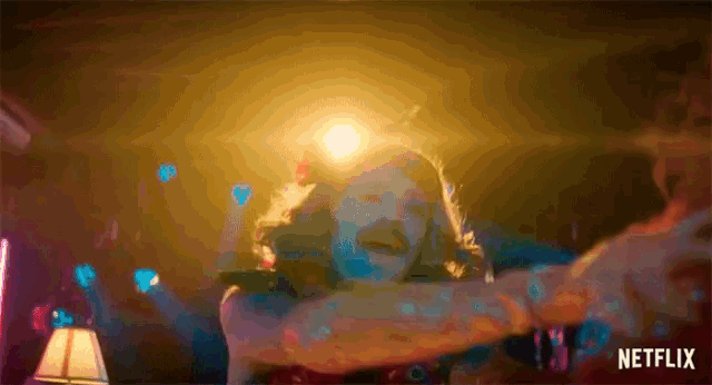 a man is dancing in a dark room with a netflix logo in the background .