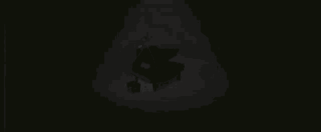 a black grand piano with a stool next to it in a dark room
