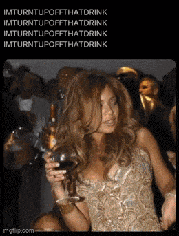 a woman in a gold dress is holding a glass of wine in her hand