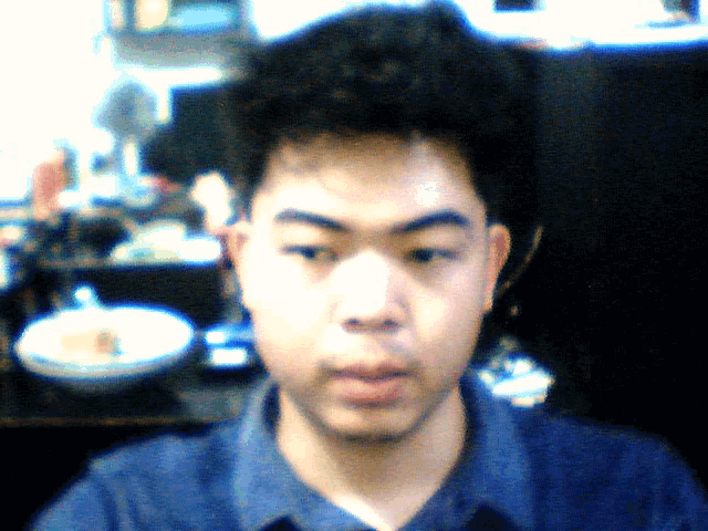 a blurry picture of a man 's face with a bowl and a fan in the background