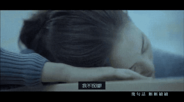 a woman is laying down with chinese writing on the screen
