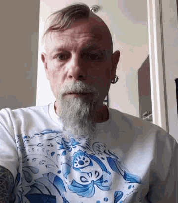 a man with a beard wearing a blue and white t-shirt