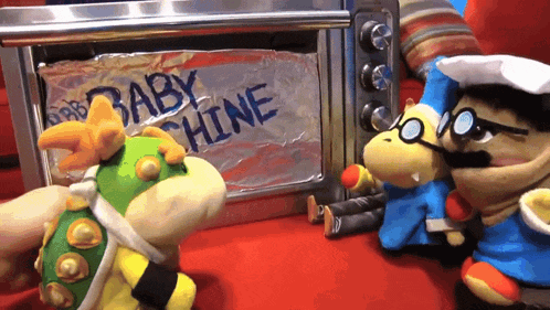 a stuffed animal standing in front of a microwave that says baby chine