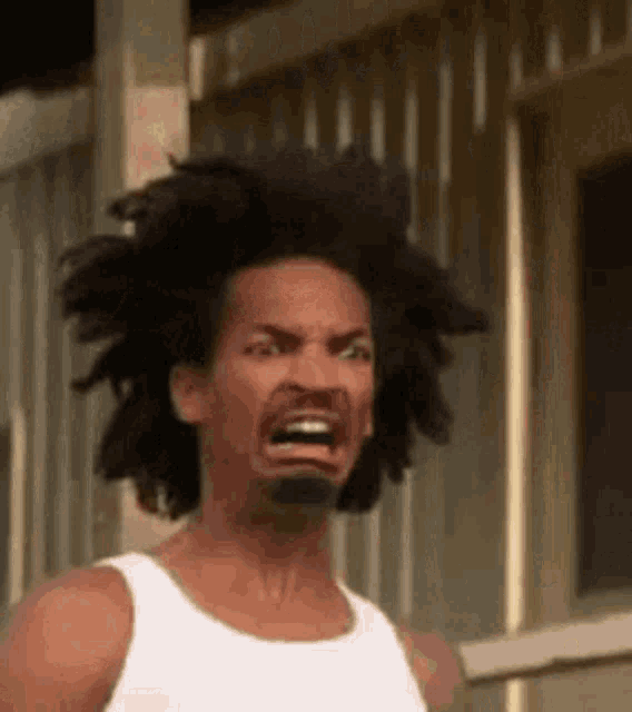 a man with a beard and long hair is making a funny face .