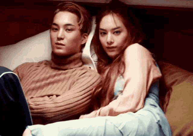 a man and a woman are sitting on a bed