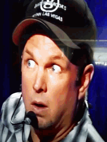 a man wearing a las vegas hat and headphones looks surprised
